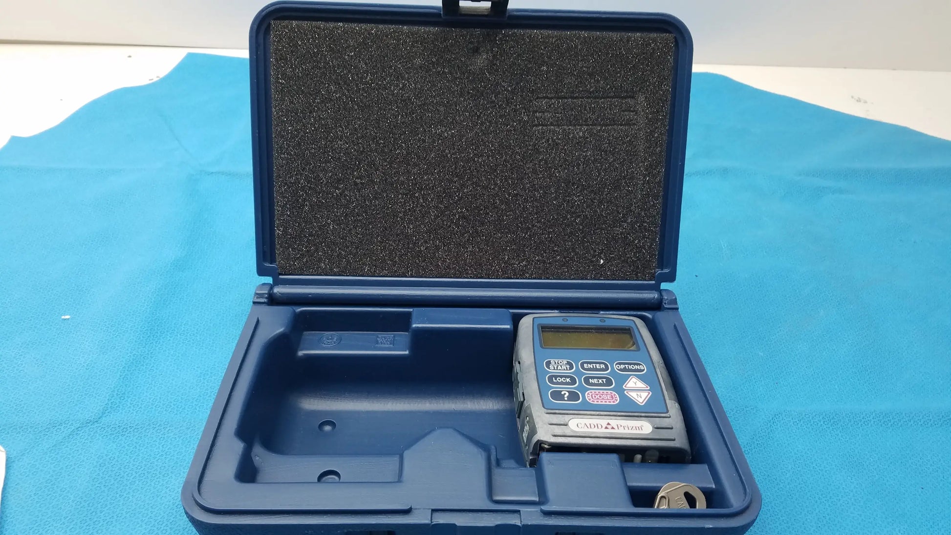 Blue hard-shell carrying case with molded foam interior housing smiths medical 6100 cadd prizm ambulatory infusion pump medical equipment