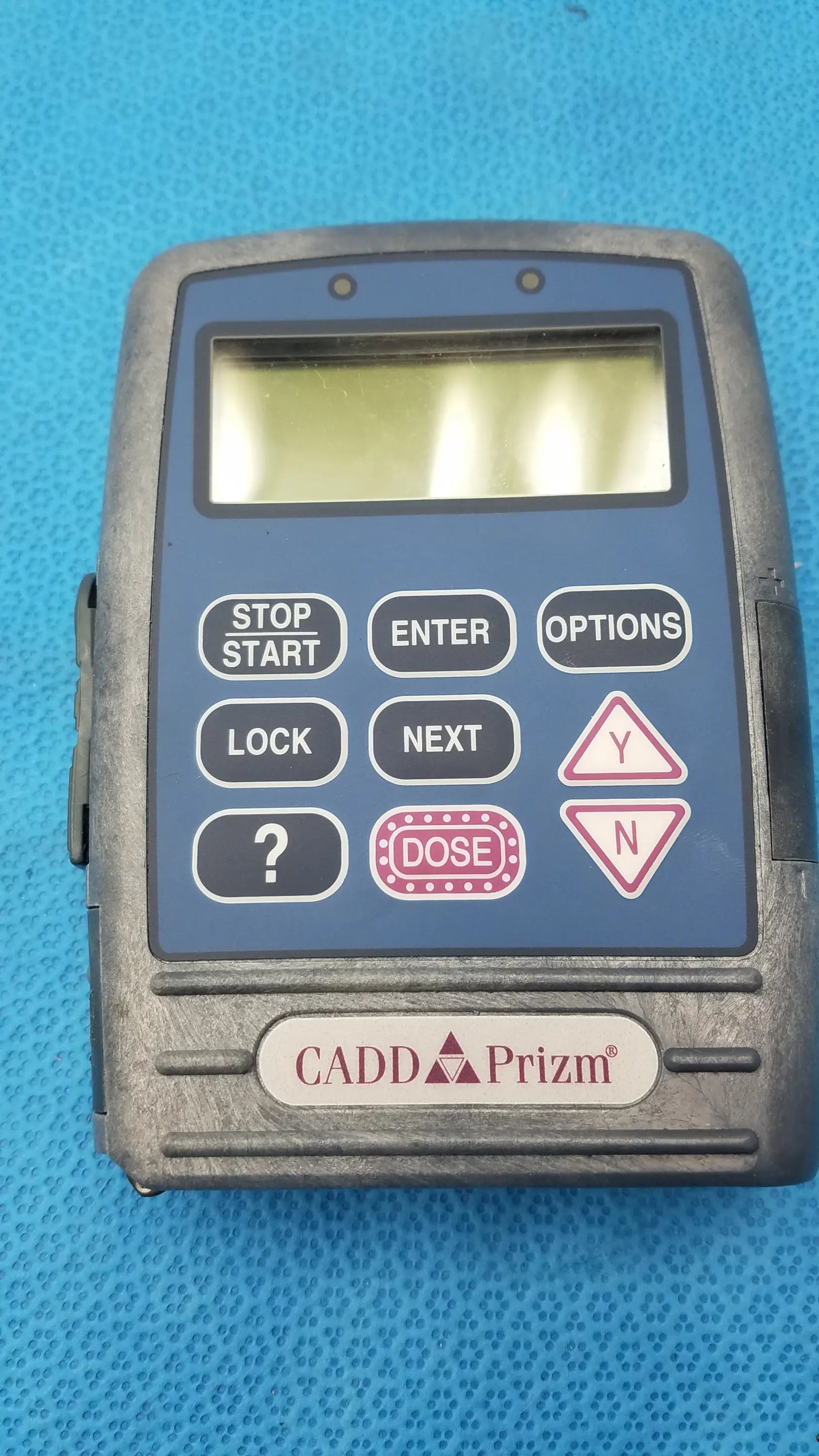 Blue cadd prizm handheld radiation dosimeter with gray plastic casing and labeled buttons in medical equipment context