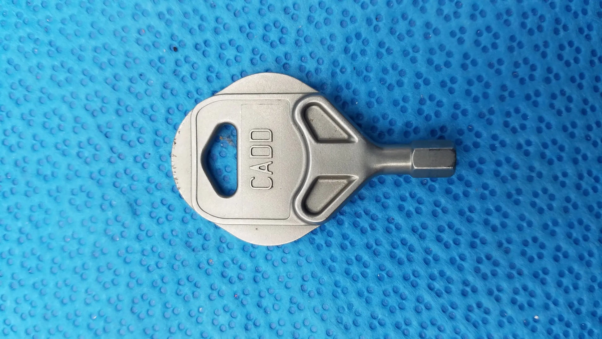 Silver metallic cadd brand medical equipment key with hexagonal bit end and cutout handle for smiths medical 6100 cadd prizm
