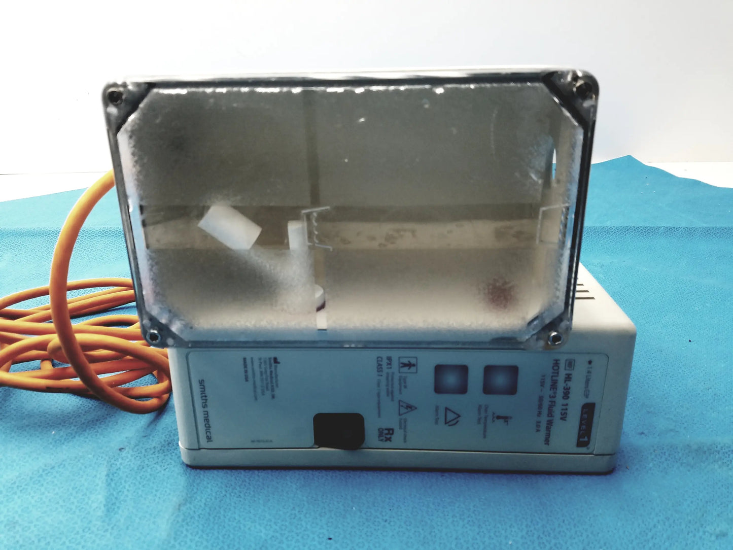 Gray rectangular smiths medical hl-390 level 1 hotline 3 fluid warmer with clear glass front panel and orange power cord medical equipment