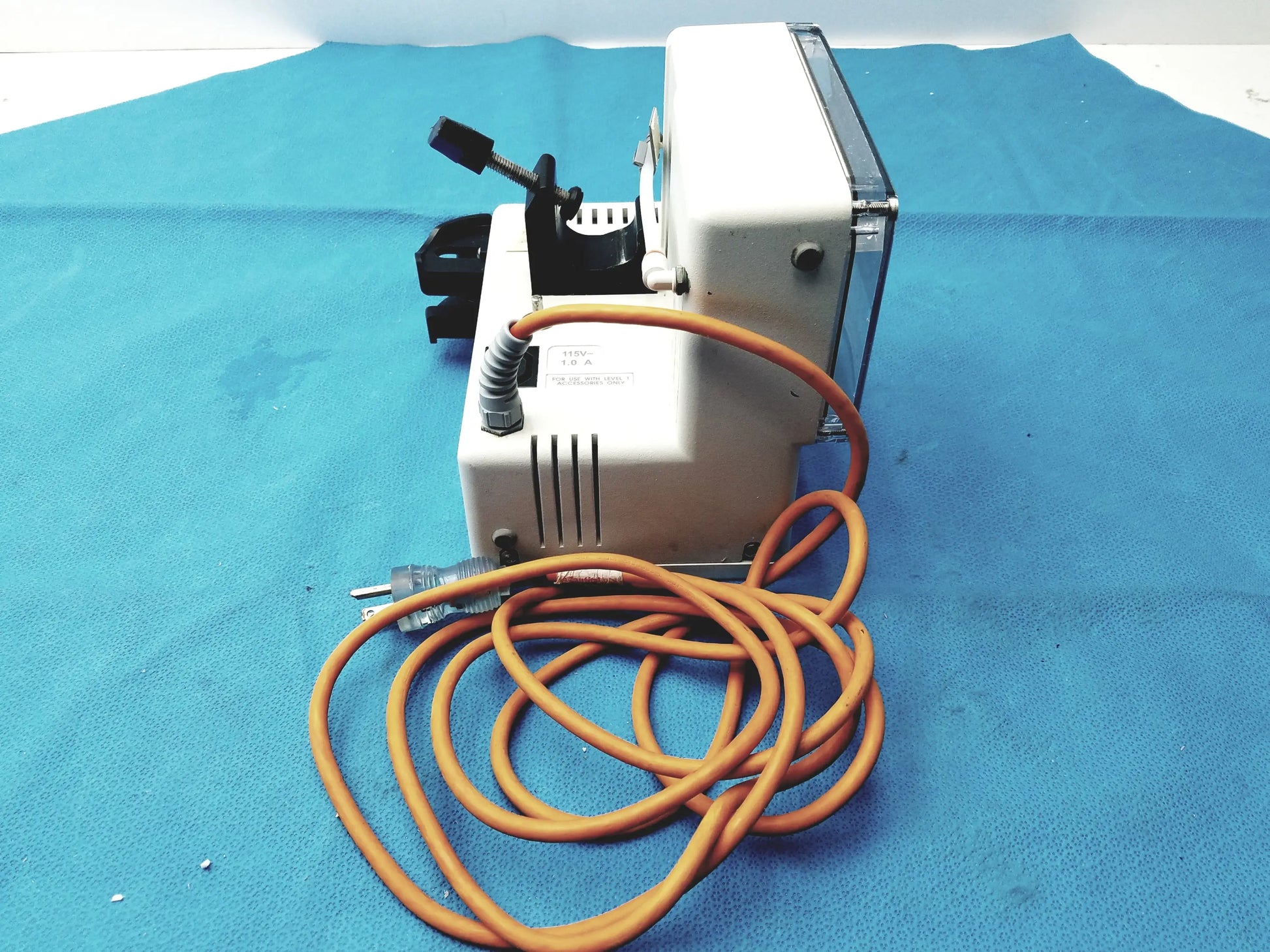 White industrial-grade vacuum pump with coiled orange cord and black components for smiths medical fluid warmer medical equipment