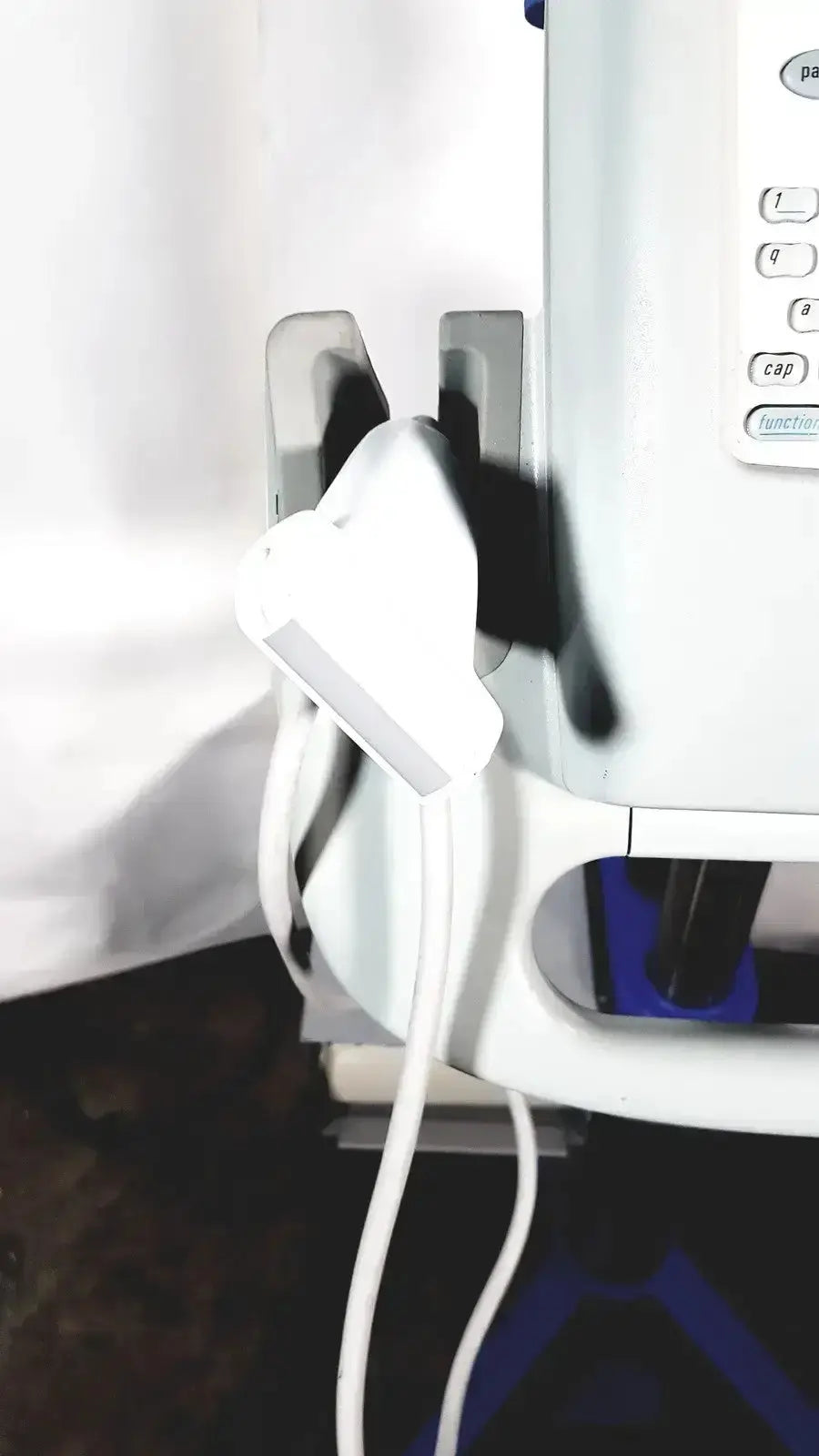 White power adapter plugged into wall outlet beside white appliance for sonosite l38 10-5 mhz linear transducer with rolling stand