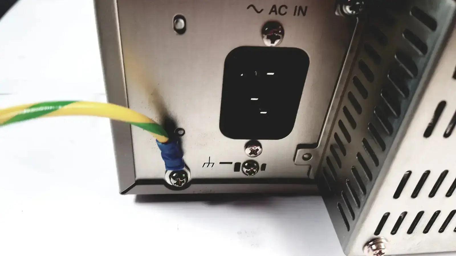 Silver metallic power supply unit with black ac input port and green yellow cable connected on back of sony svo-9500md medical svhs vhs