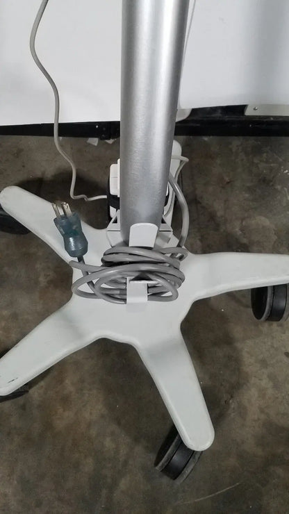 Silver metallic pole mounted on white plastic star-shaped rolling stand base with black caster wheels for spacelabs patient monitor medical equipment