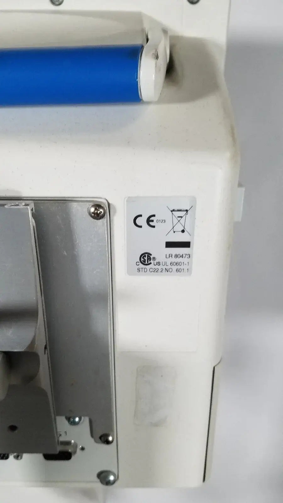 Spacelabs SL 91369 Ultraview patient monitor with white plastic body blue cylindrical part and metal mounting bracket on rolling stand medical equipment