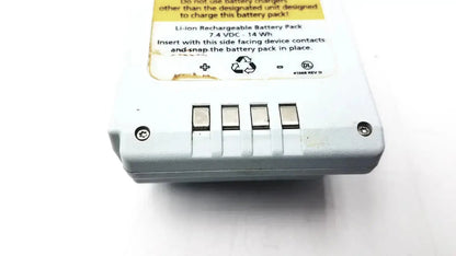 White plastic li-ion rechargeable battery module with four metallic contacts and yellow warning label for wireless battery use