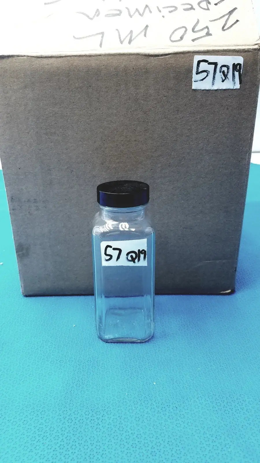 Clear glass square glass bottle with black lid and white label code 57 q19 for laboratory reagent or reuse medical equipment