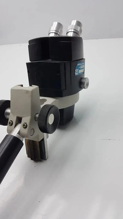Black and silver reichert stereo star zoom microscope with beige adjustable stage clamp for precise magnification