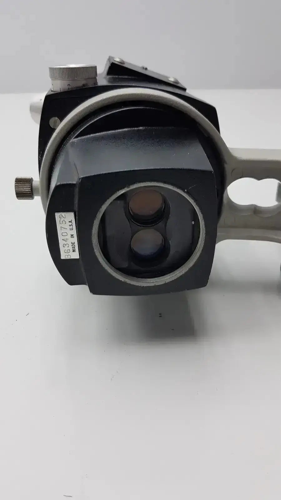 Black and silver reichert stereo star zoom microscope with two circular lenses and metallic adjustment knob on the side