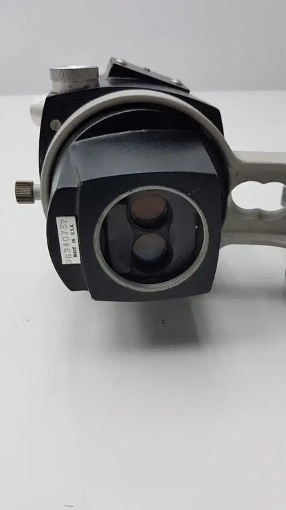 Black and silver reichert stereo star zoom microscope with two circular lenses and metallic adjustment knob on the side