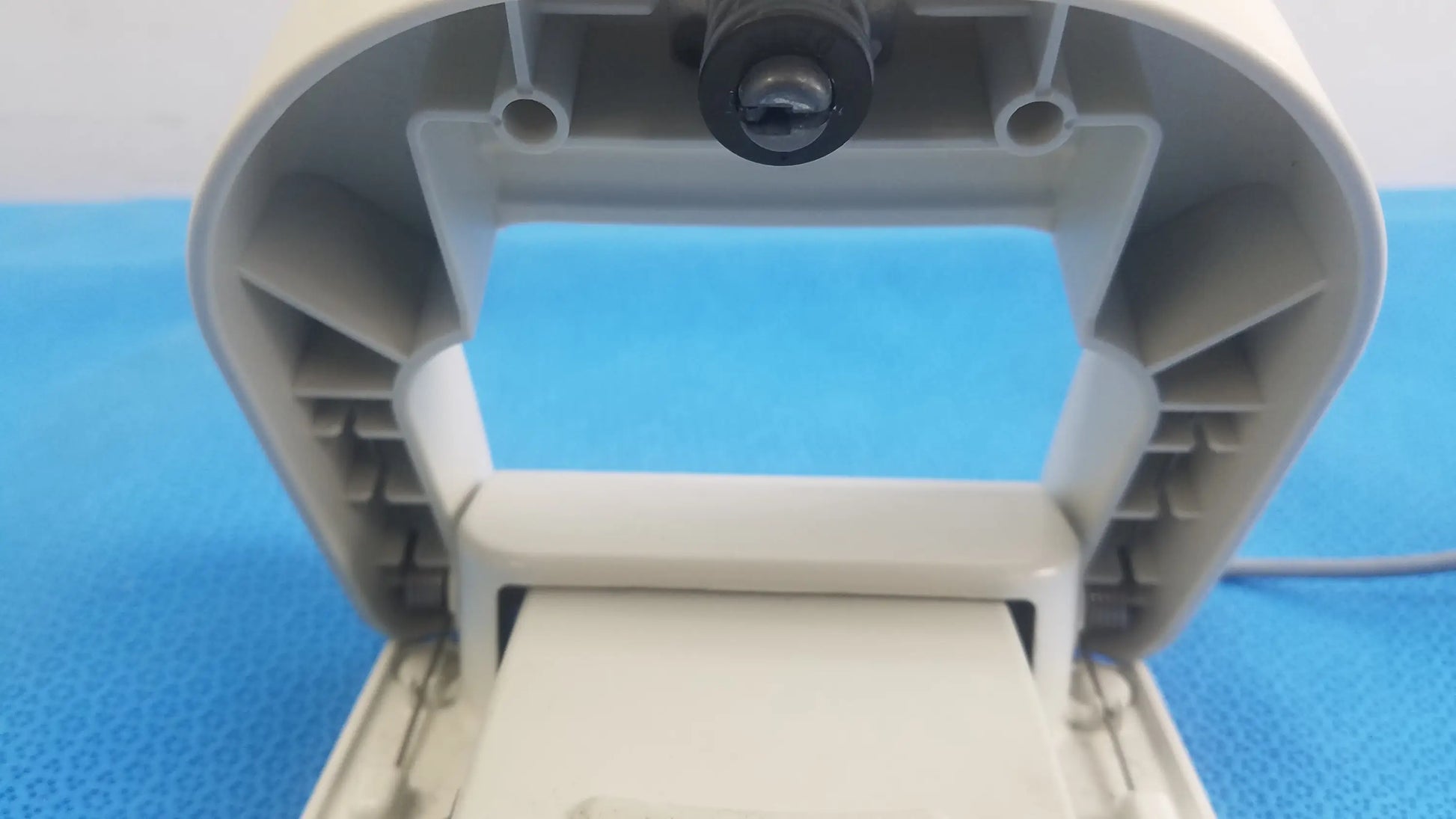 Beige plastic toilet paper dispenser with black circular sensor for reuse medical equipment in stokert smartablate system foot pedal ref m490005