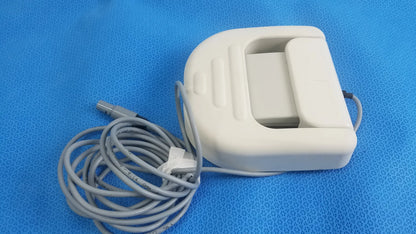 White plastic foot pedal ref with coiled gray cable and connector for stokert smartablate system medical equipment reuse