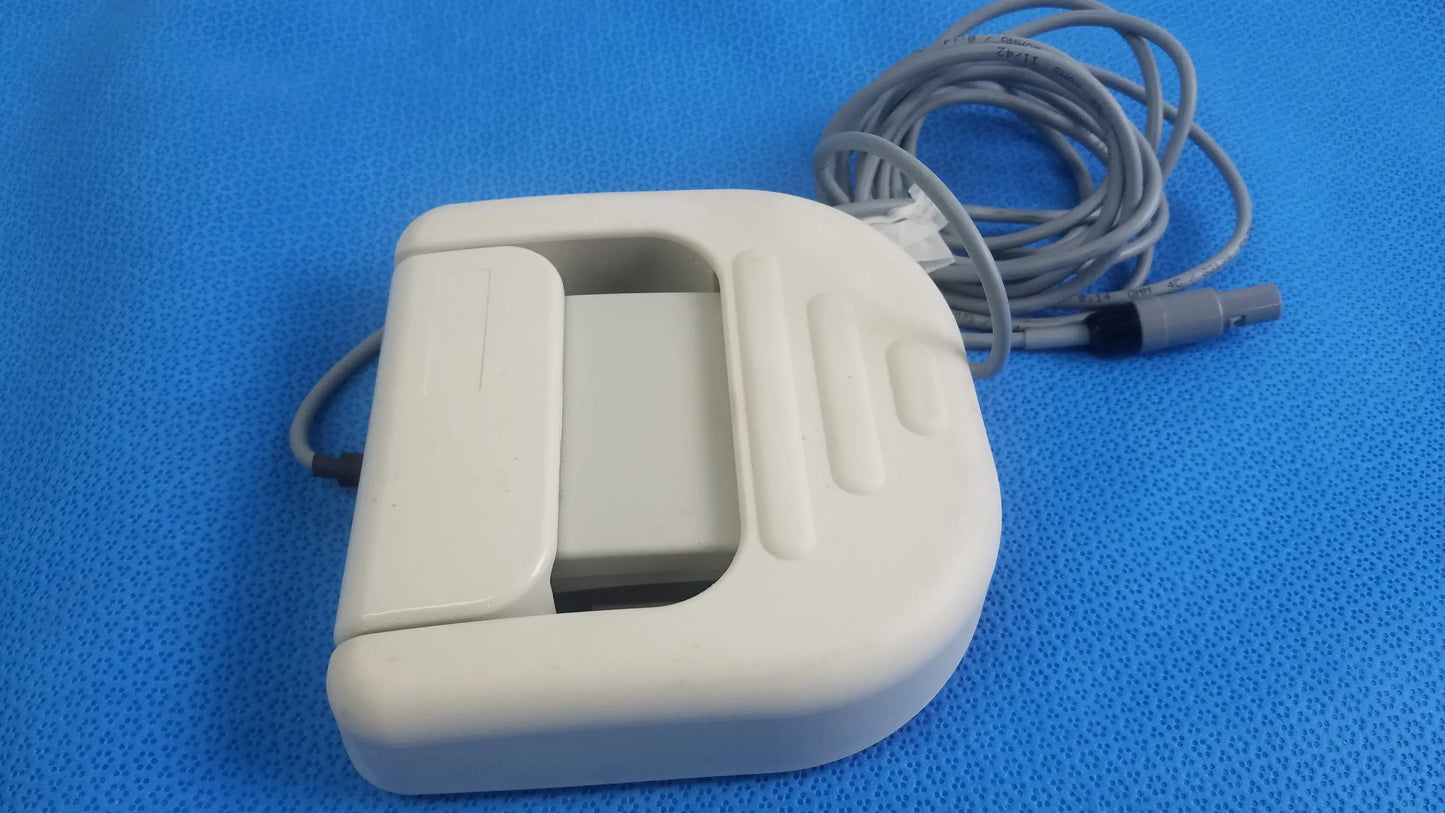 White plastic Stokert SmartAblate system foot pedal ref M490005 with coiled gray cable for medical equipment use