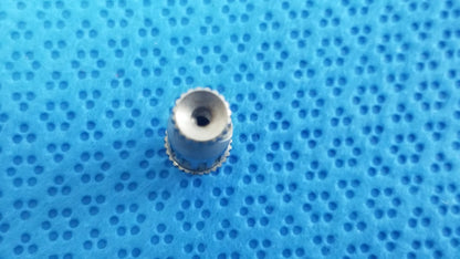 Silver-colored metal watch crown with ridged edge and hole for straumann ultrasonic cleaning cassette reuse medical equipment