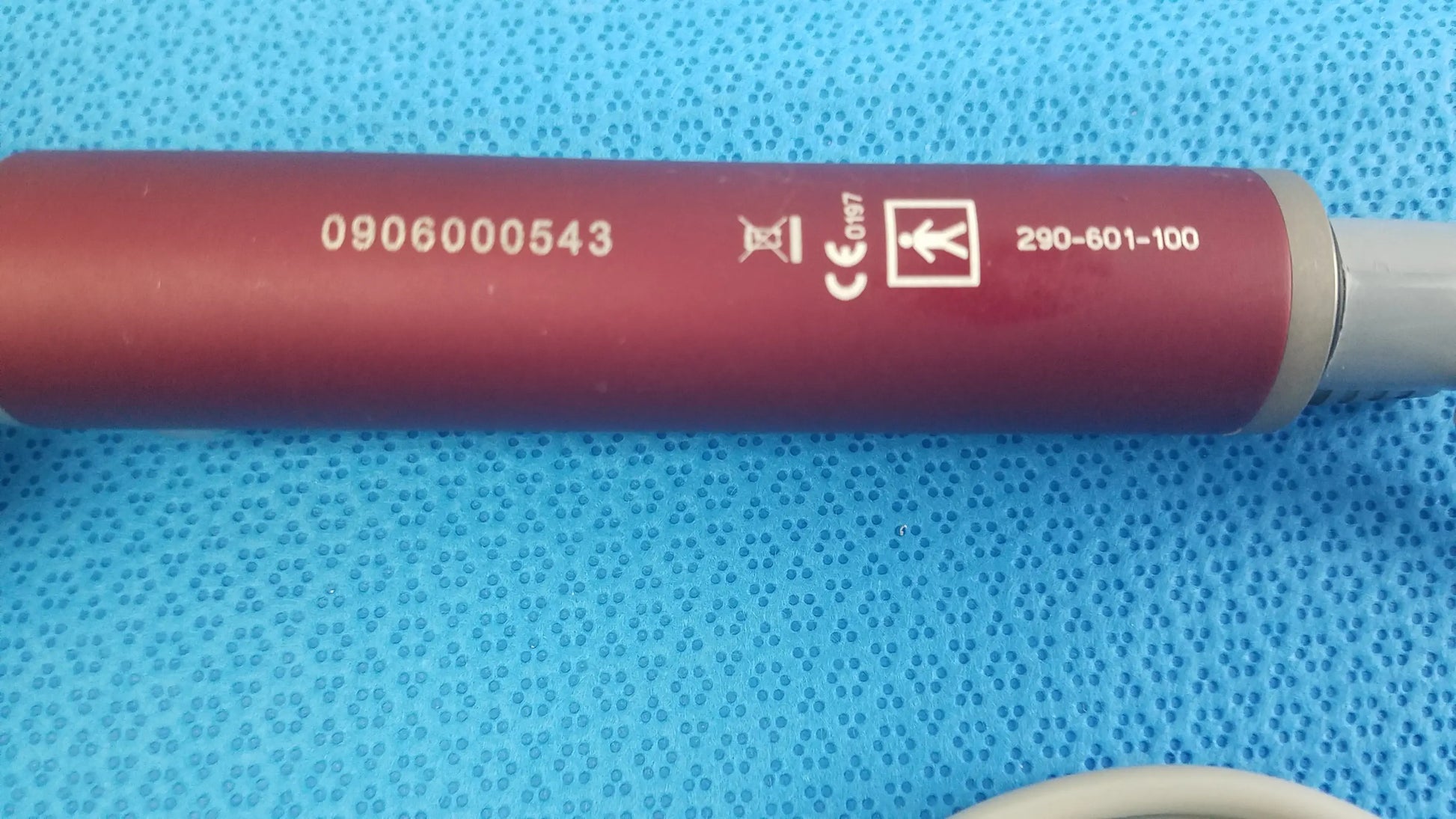 Red cylindrical tps leibinger hummer shaver handpiece with gray end cap and engraved serial number and certification marks