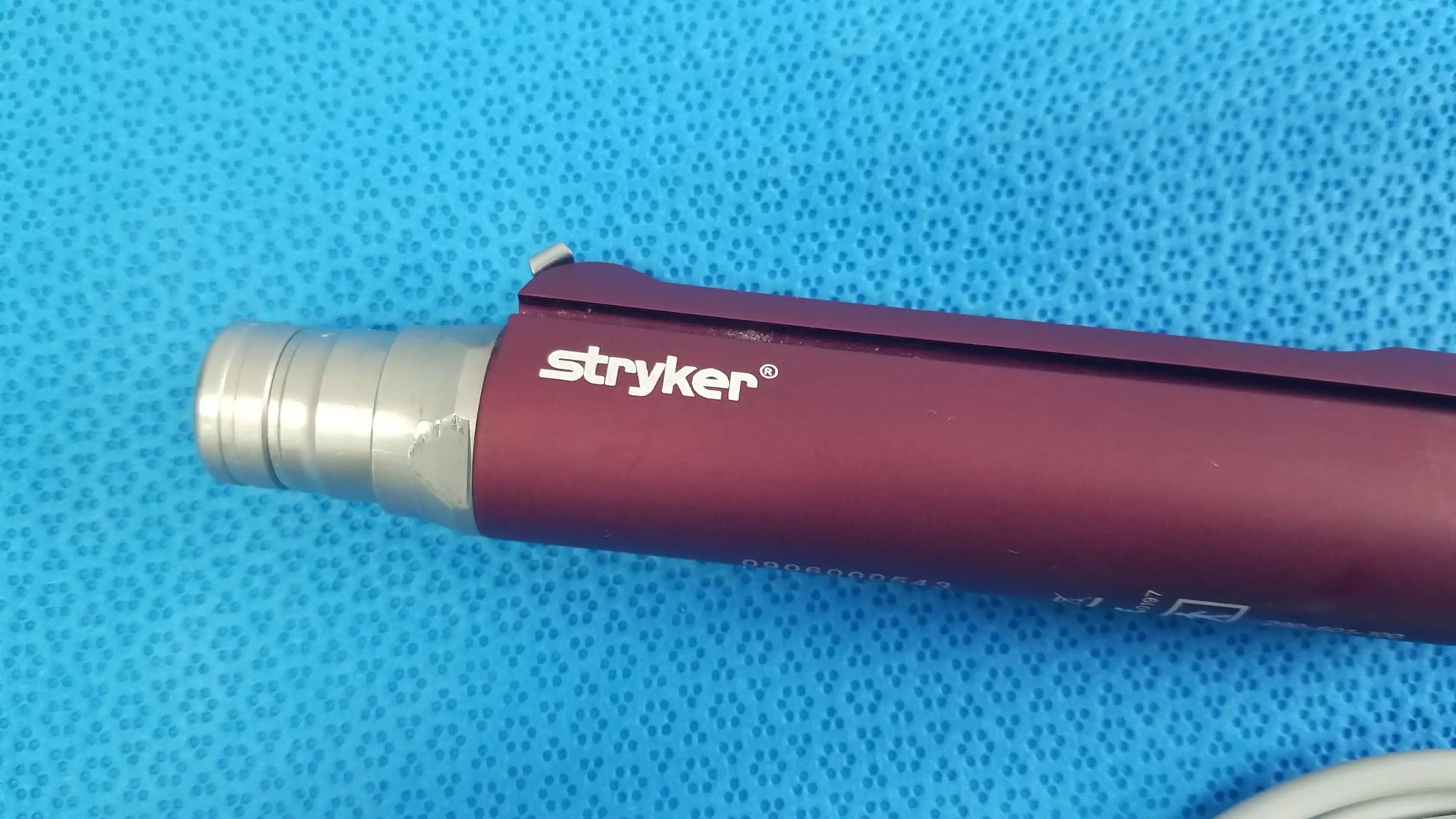 Maroon and silver tps leibinger hummer shaver handpiece with textured grip for precise surgical use