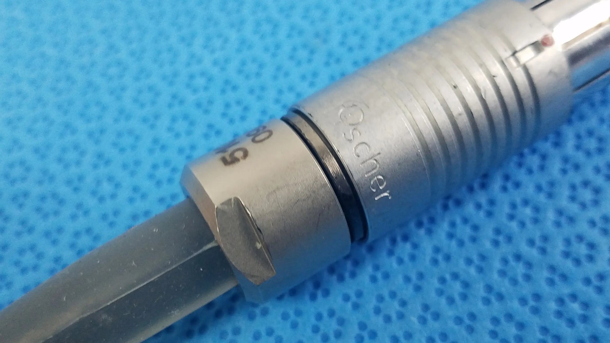 Silver-colored metal scher handpiece cable with engraved oscher branding and ribbed grip for reuse medical equipment