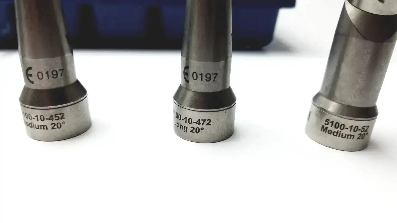 Three metallic fuel injector nozzles with engraved specs in the stryker 5400-277 core sterilization case for medical use