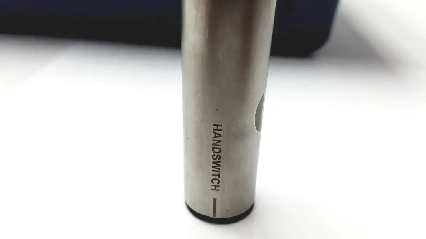 Silver cylindrical vape pen engraved with handswitch beside stryker 5400-277 core sterilization case with drill attachments