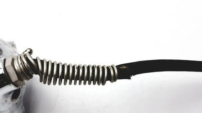 A coiled metallic spring with a hexagonal nut attached to a damaged black cable on stryker 8381-210 autopsy saw for biomedical technicians hospital surplus