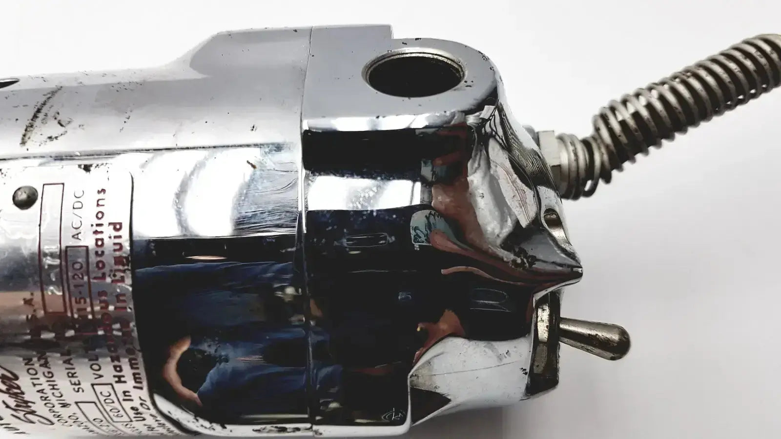 Chrome-plated metal motor housing with coiled spring and threaded rod on stryker 8381-210 autopsy saw for biomedical technicians in hospital surplus