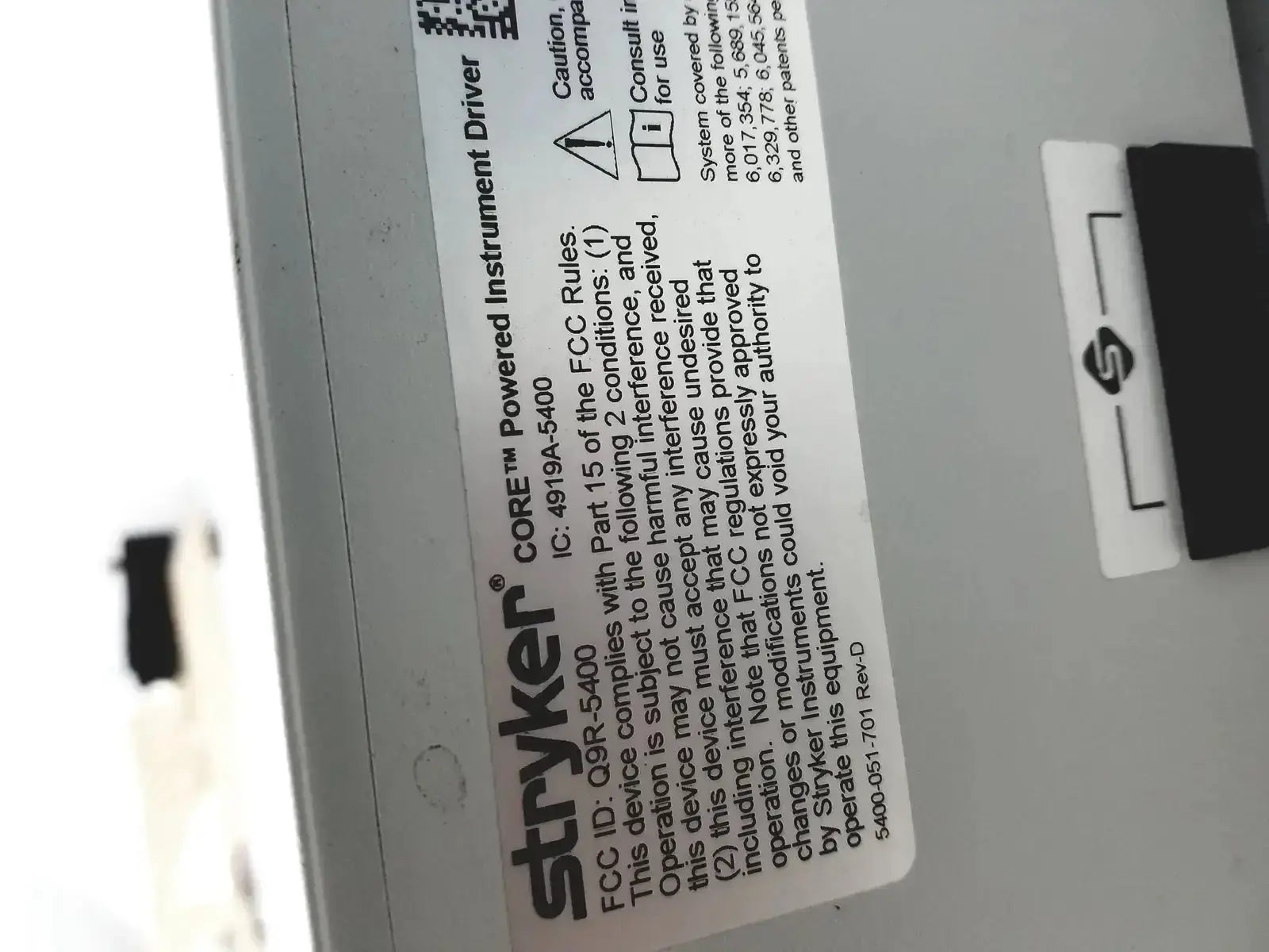 White rectangular label with black text and qr code on stryker coer powered instrument driver ref 5400-050-000