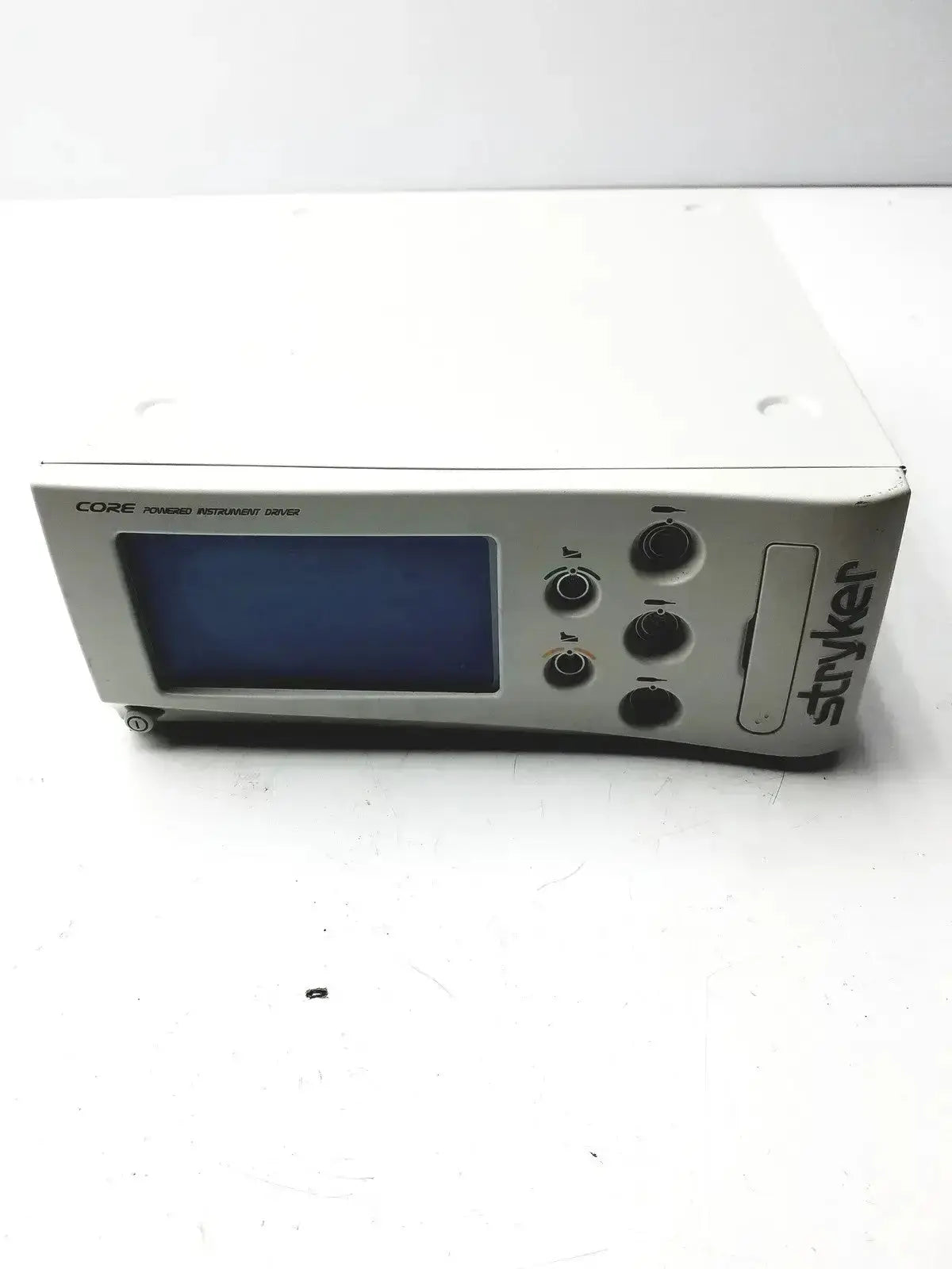 White stryker core powered instrument driver with blue screen and black control knobs for precision control