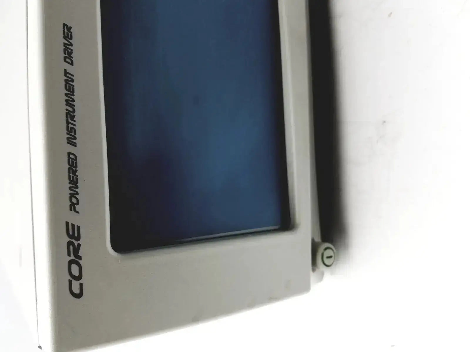 Gray plastic stryker powered instrument driver with dark blue screen and black vertical text core powered instrument driver