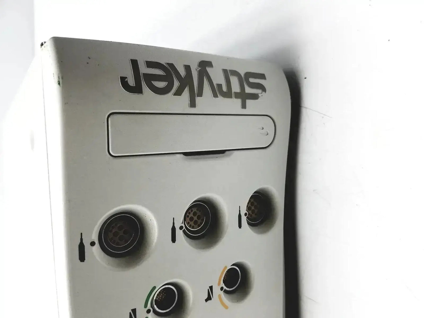 White plastic stryker powered instrument driver with black lettering and circular dispensing slots for medical use