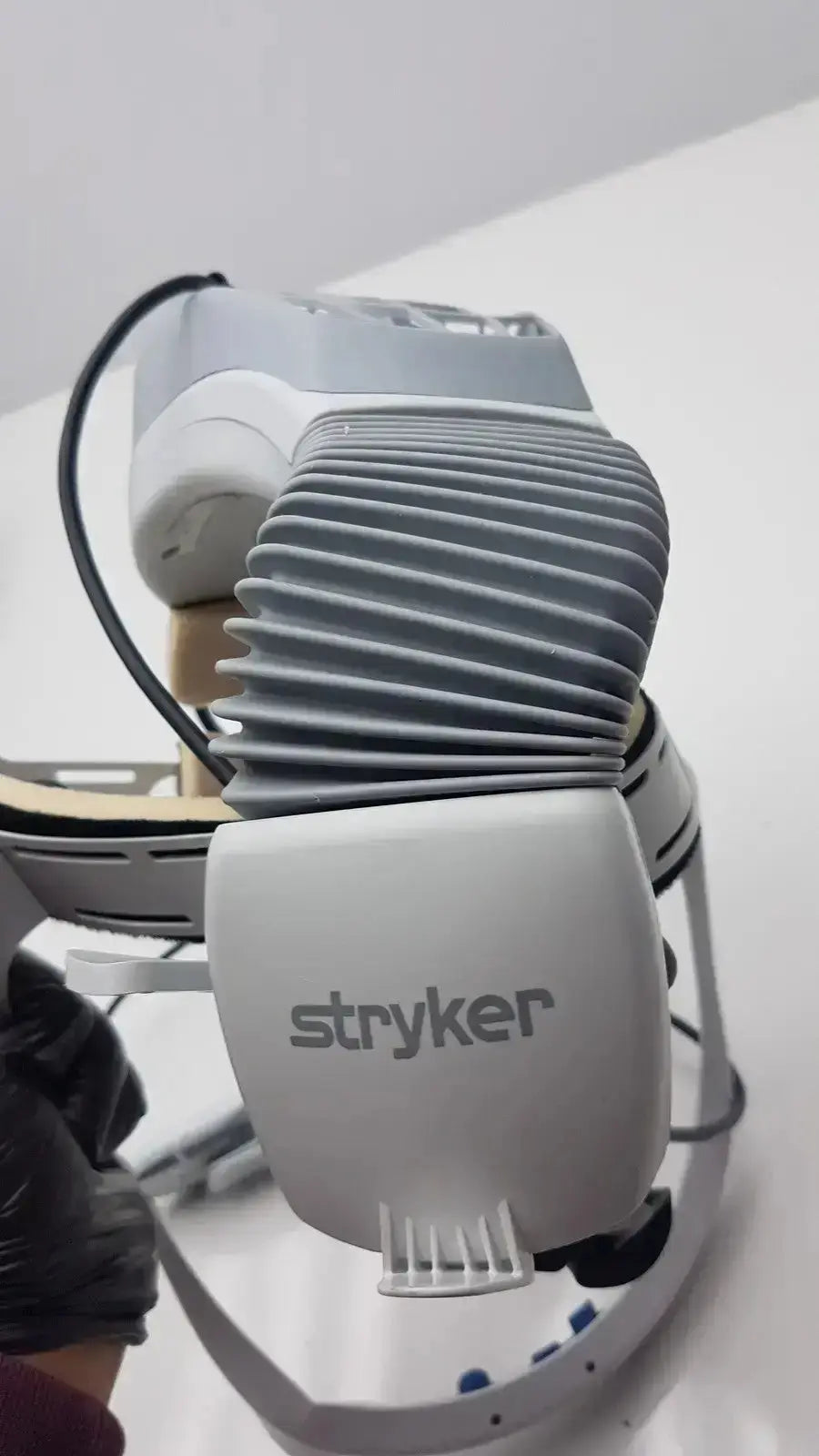Gray stryker flyte helmet surgical robot arm with ribbed cooling fins and sleek modern design for precise operations