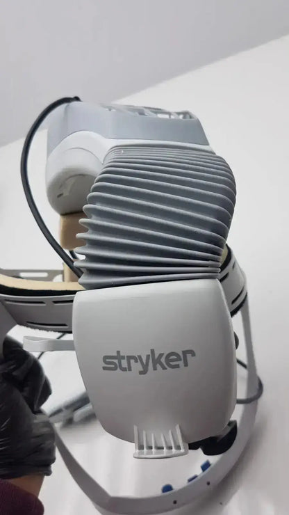 Gray stryker flyte helmet surgical robot arm with ribbed cooling fins and sleek modern design for precise operations