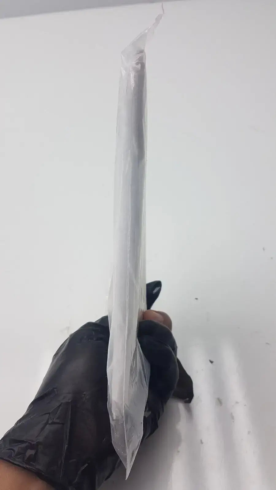 A sleek transparent plastic-wrapped SunTech Medical single patient use blood pressure cuff held by a gloved hand