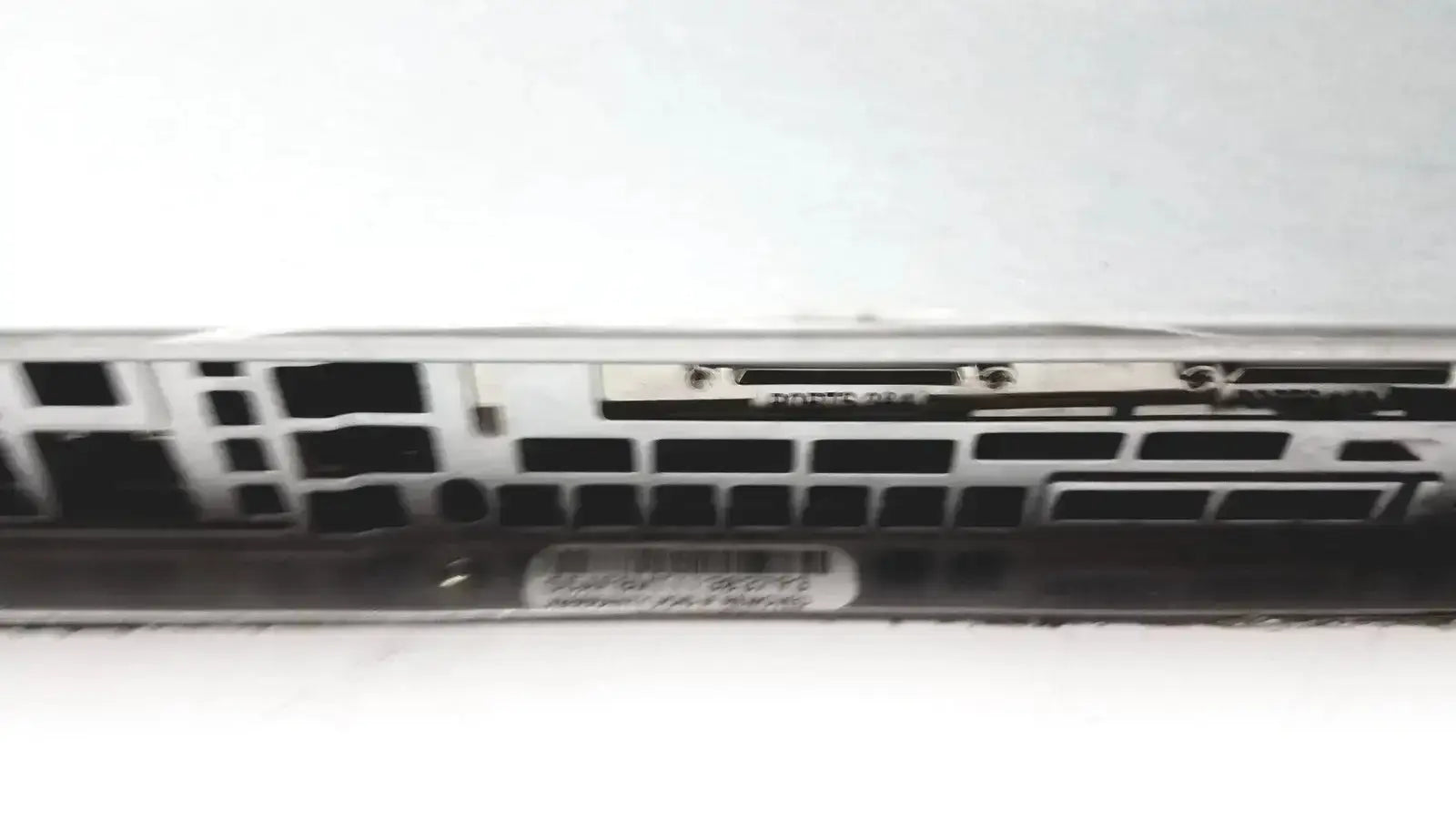 Silver-colored metal supermicro 5015b-mt super server rack showing black rectangular ports and ventilation slots on back side