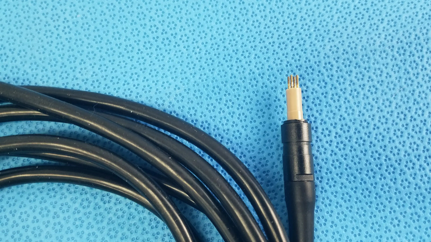 Black coiled surgical scher handpiece cable console connector with beige core and four metallic pins for medical equipment use