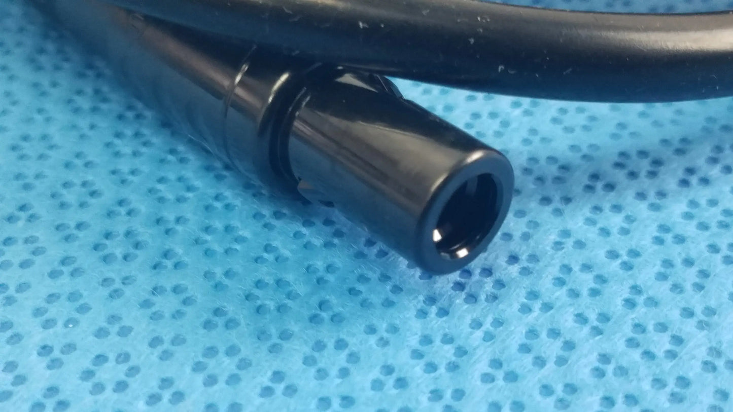 Black plastic cylindrical connector with a glossy finish for surgical scher handpiece cable console in medical equipment