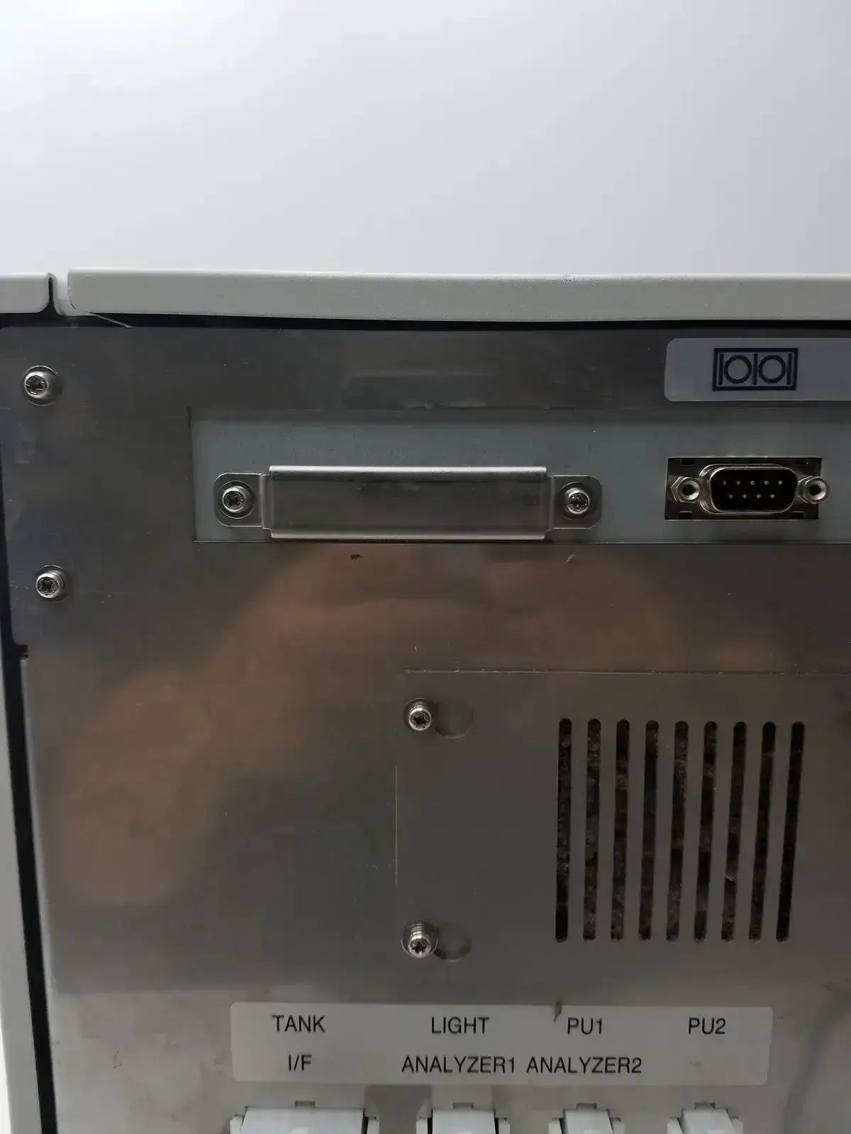 Silver metallic rear panel of sysmex ru-20 reagent delivery system with d-sub port ventilation slits and labeled switches