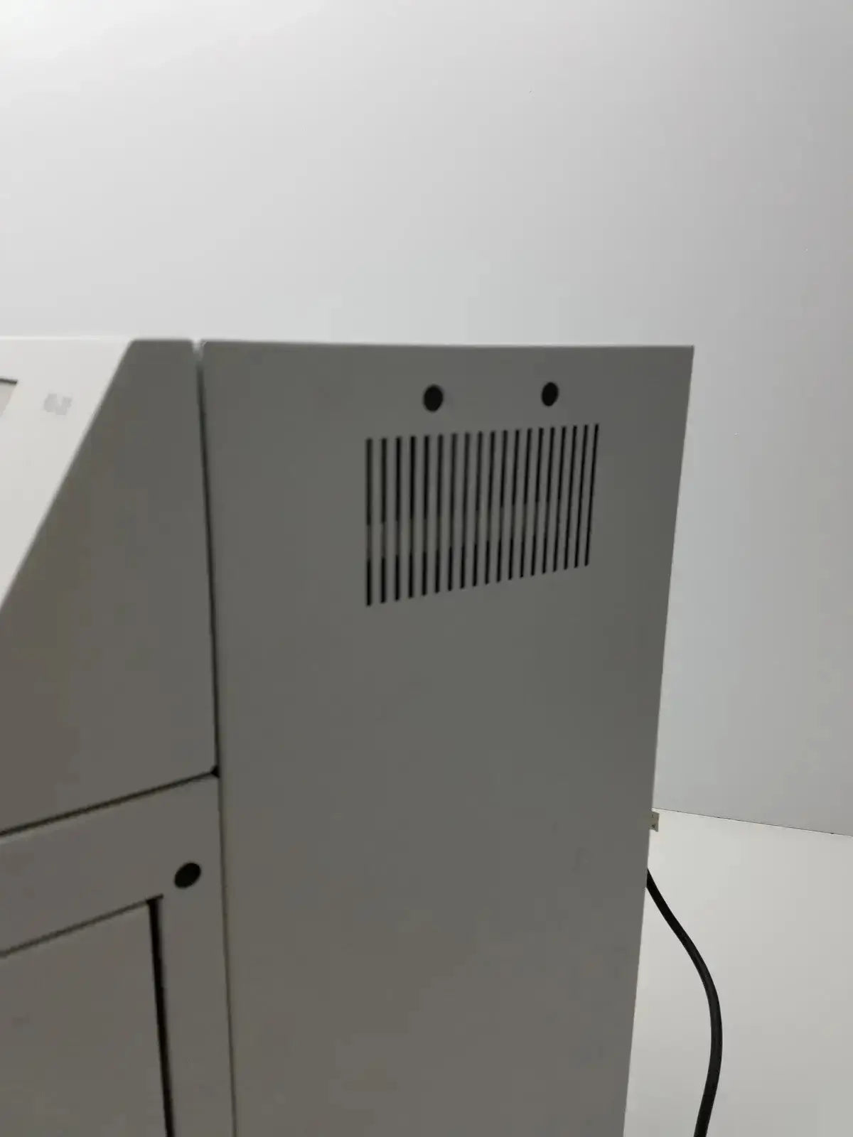 Gray plastic Sysmex RU-20 reagent delivery system laboratory printer back with vertical vent grille and two circular holes