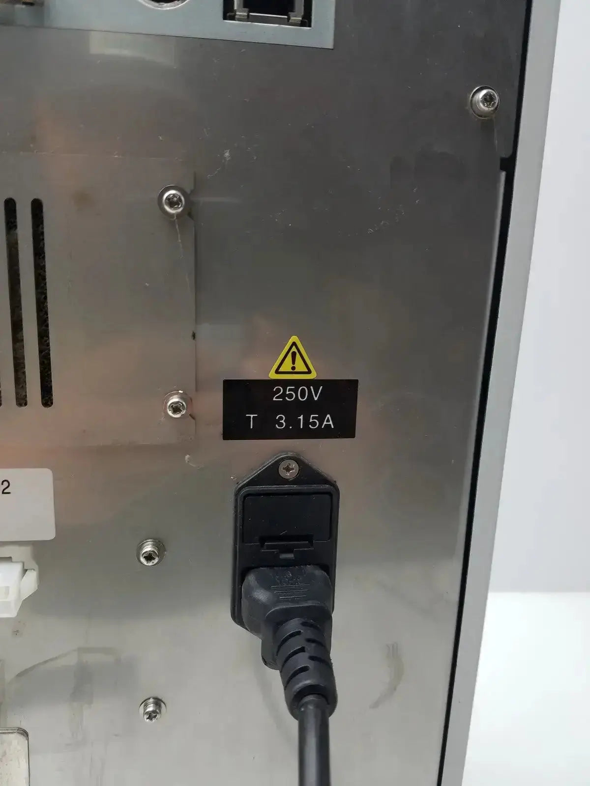 Black power cord plugged into stainless steel sysmex ru-20 reagent delivery system with 250v 3.15a rating on back side