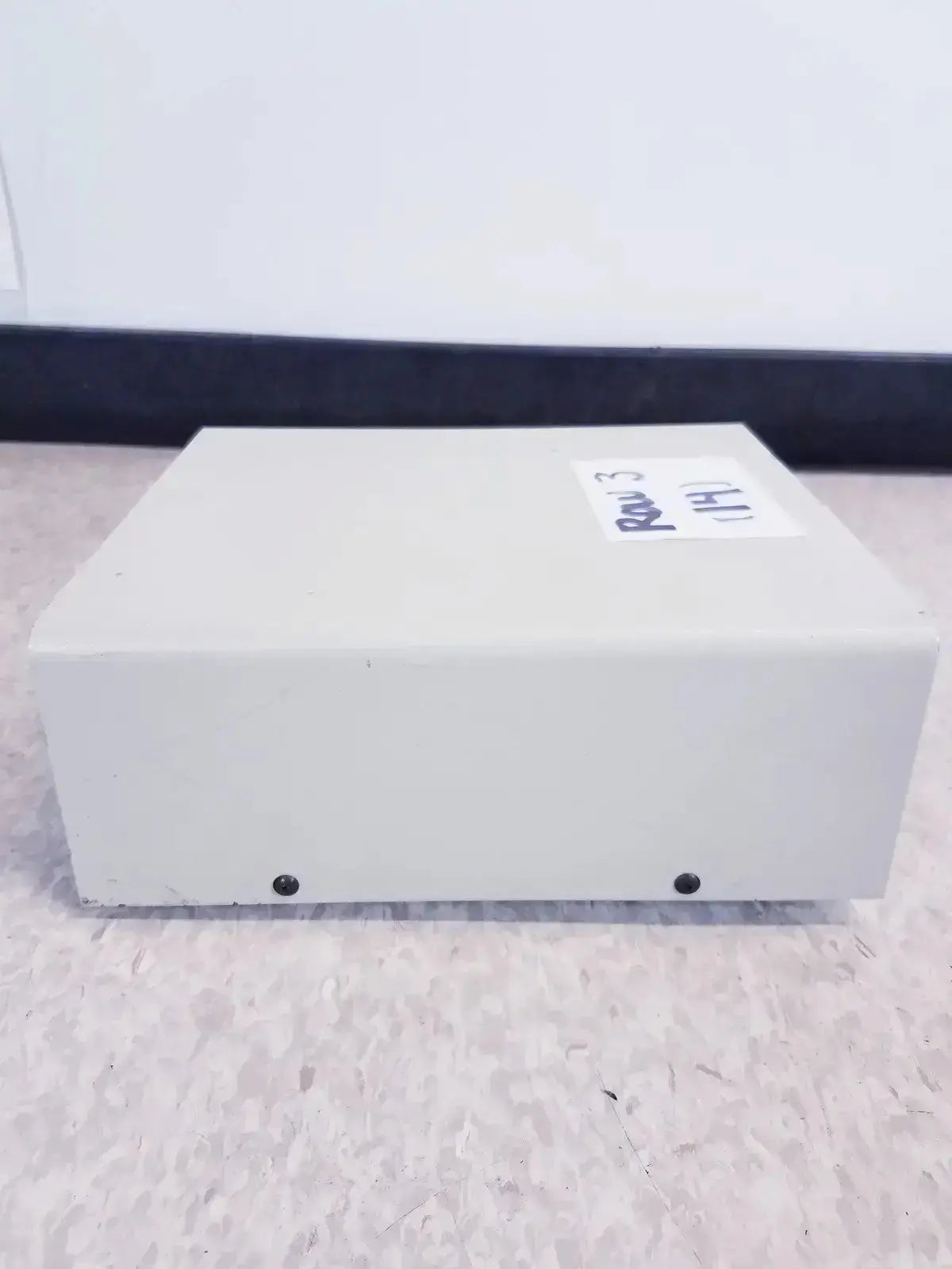 Off-white rectangular digital tabletop dual temperature controller with white label and two black screws on bottom side