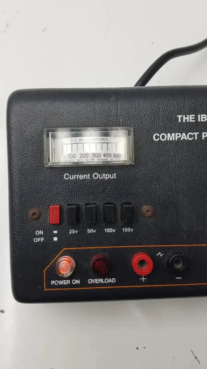 The IBI CPS 500 compact power supply is a black textured plastic unit with current output meter and red indicator lights