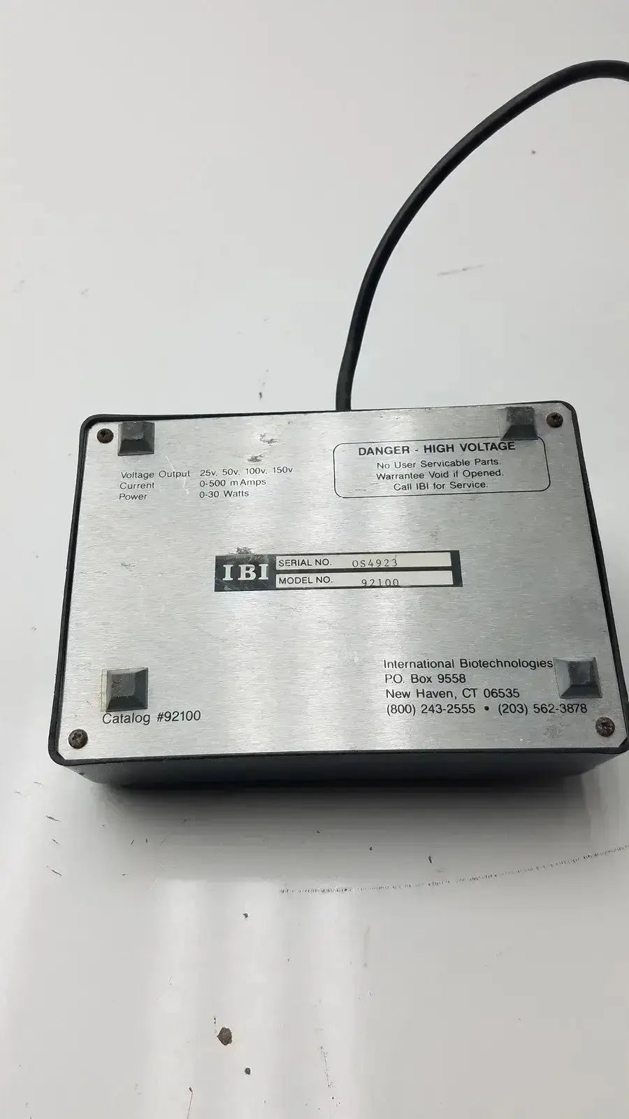 The back side of a silver metallic ibi cps 500 compact power supply model 92100 with black cable and printed specs