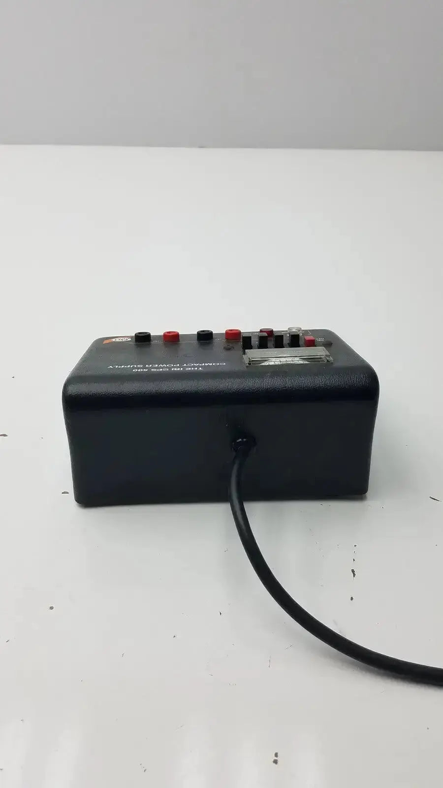 The ibi cps 500 compact power supply is a black rectangular device with red and black knobs a silver label and power cord
