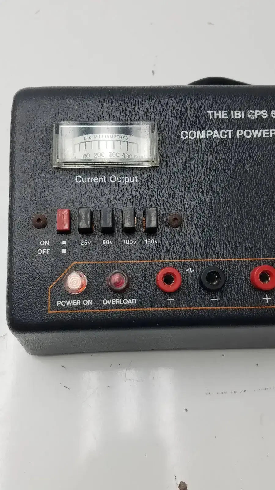 The IBI CPS 500 compact power supply model 92100 features a black leather-textured case with silver dial and red black terminals
