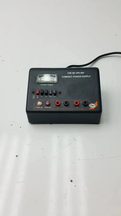 Black plastic ibi cps 500 compact power supply model 92100 with red and black output jacks and analog meter