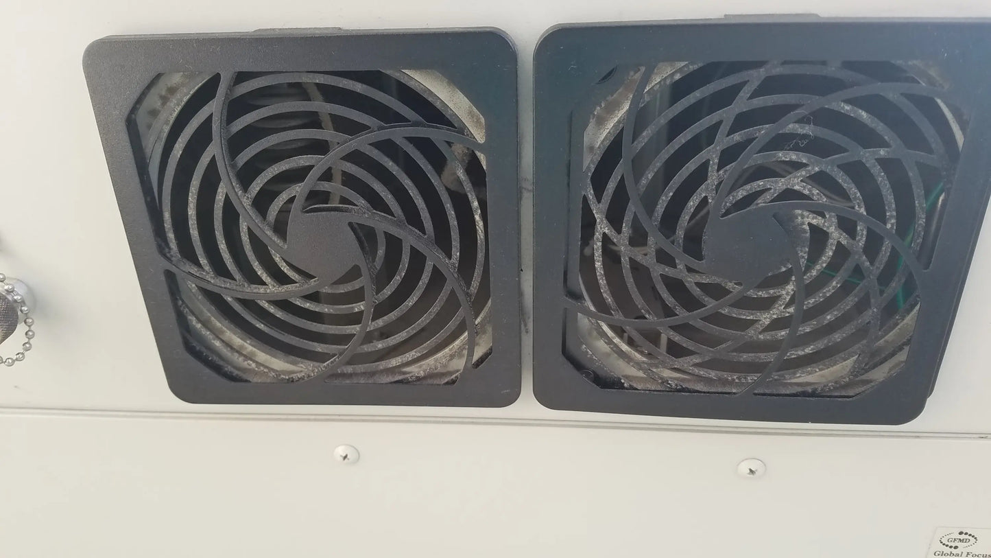 Two black square ventilation fans with spiral blade grilles on the back of the silent solution silencer 2310 centrifuge system for medical equipment reuse