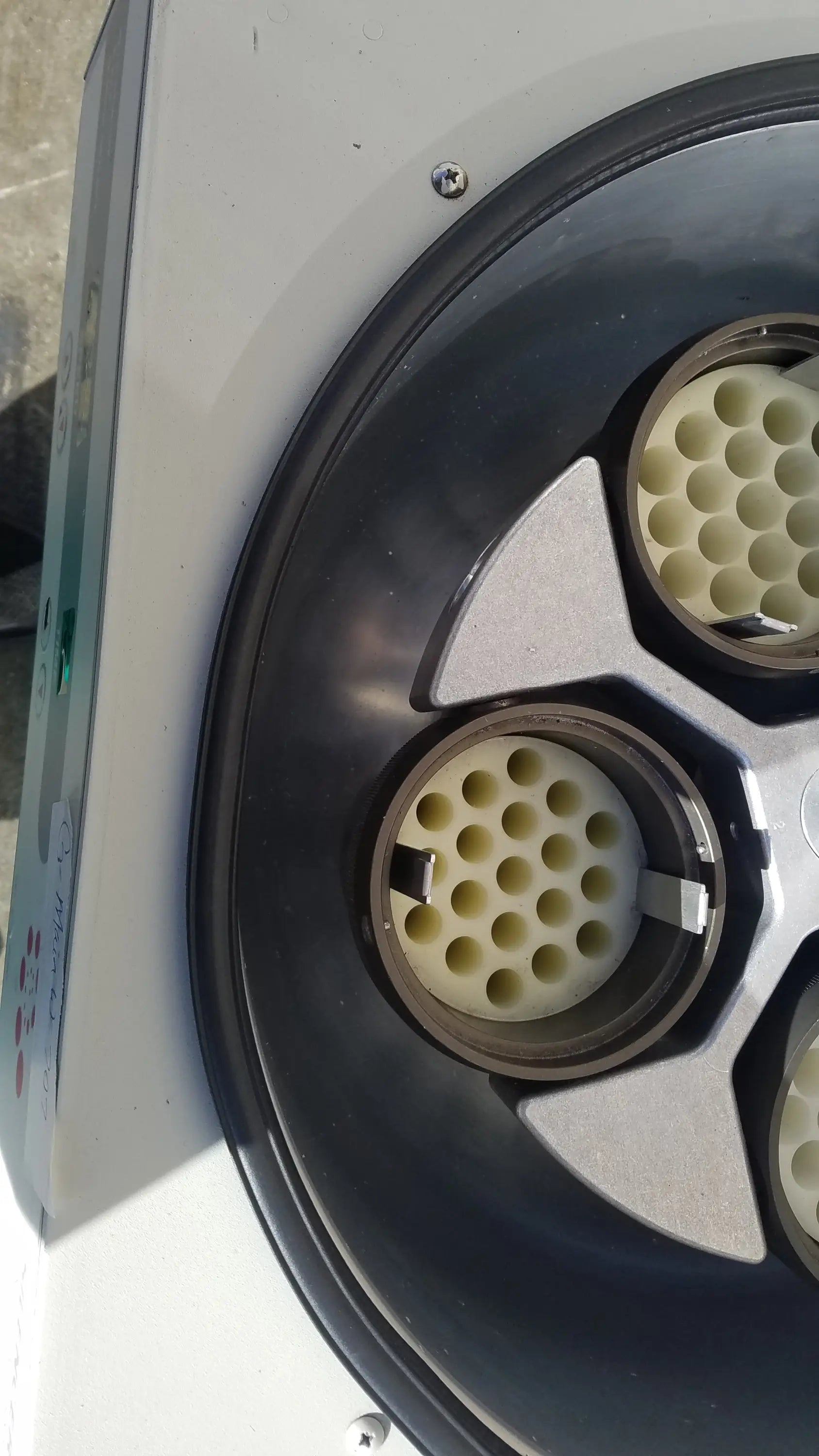 White and black circular silent solution silencer with three beige perforated inserts in a metallic frame for medical equipment
