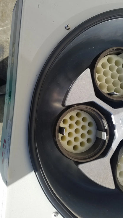 White and black circular silent solution silencer with three beige perforated inserts in a metallic frame for medical equipment