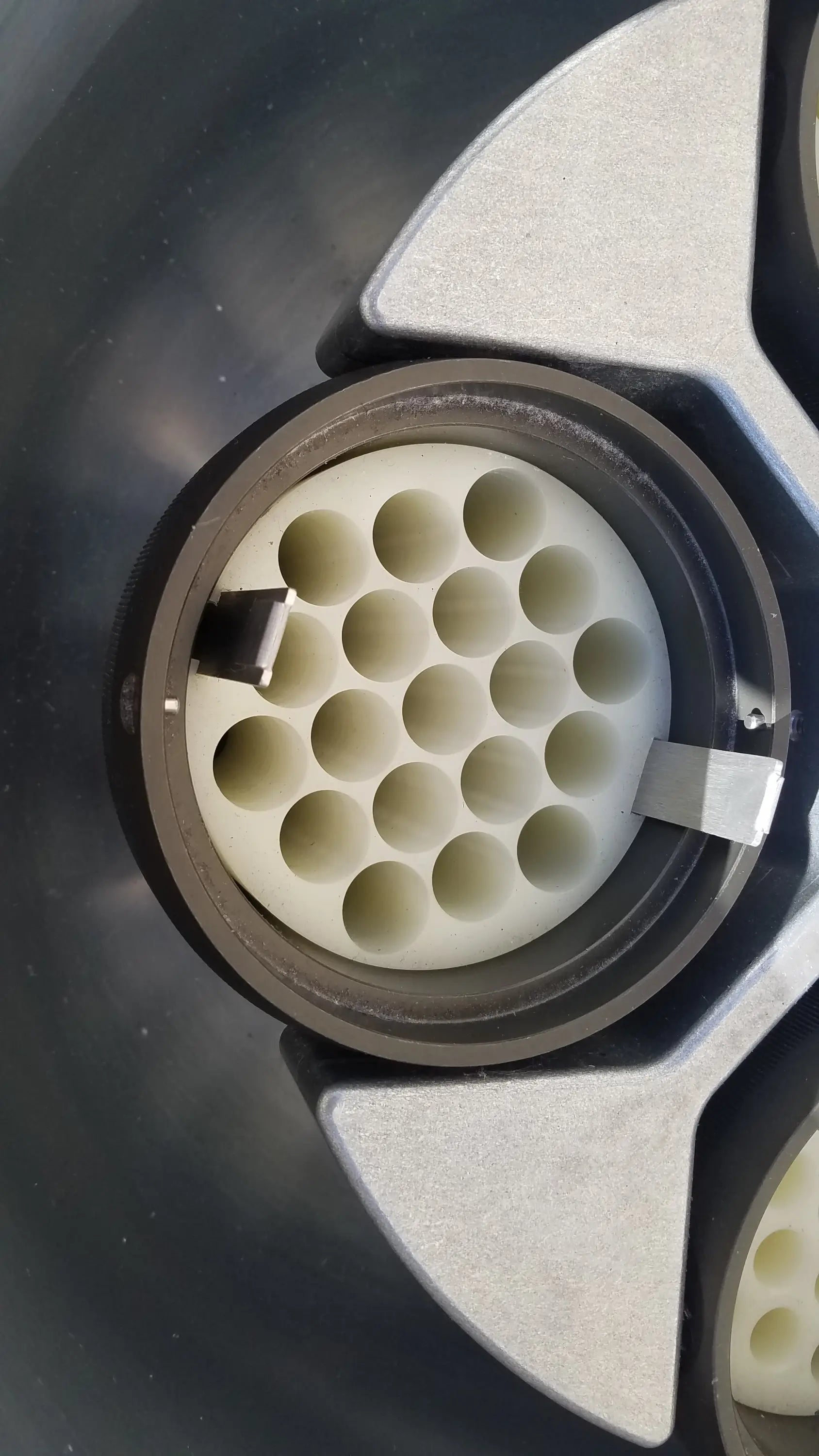 White plastic connector with 24 cylindrical holes in black ring and silver housing for silent solution silencer medical equipment