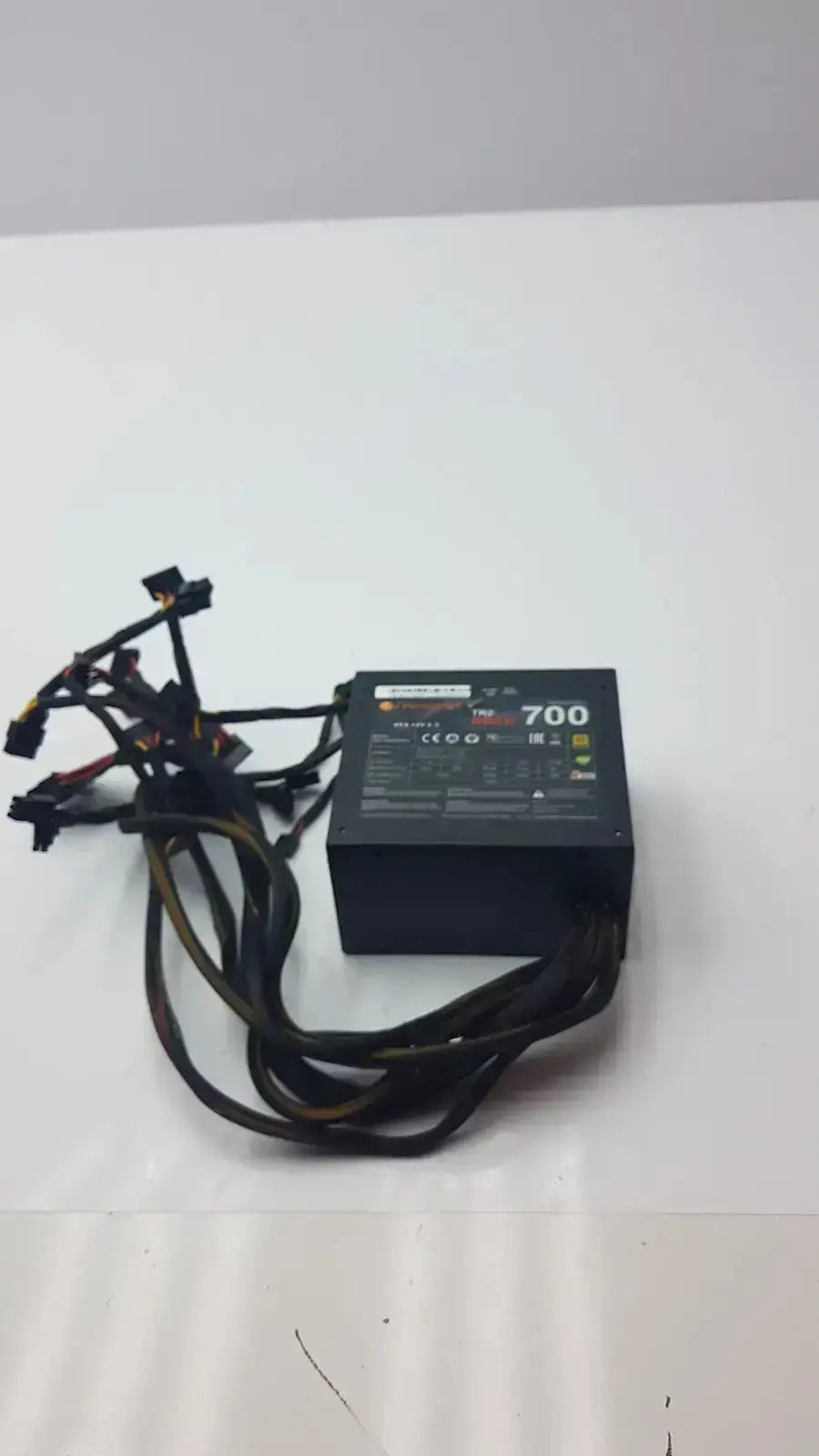 Black thermaltake tr2 700w atx 12v power supply unit with multiple black cables and 700 label on top surface