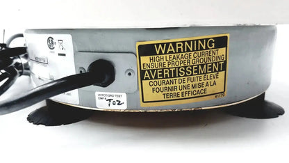 Gray metallic circular iec centra cl2 centrifuge device with black rubber feet and bilingual warning label visible